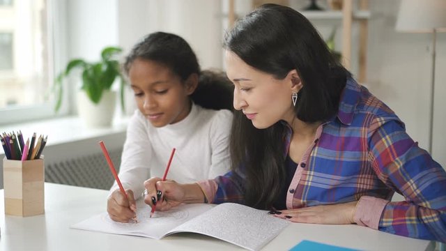 Charming little female is doing her homework to improove math skills. African smart girl doing exercises in middle school to improve her intelligence.
