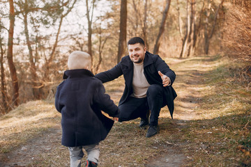 Family in a summer park. Father in a brown sweater. Cute little son