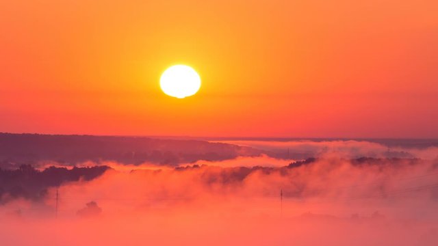 Timelapse of sunrise on misty valley