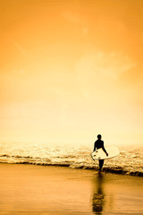 Surfer on the beach and sandy sea shore with the beautiful golden sunset  view.