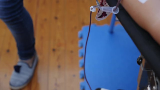 A nurse draws blood from a tube hooked to the patient to fill a vile for testing