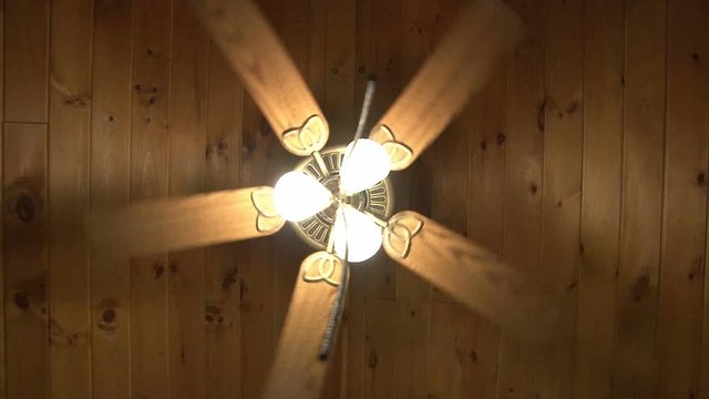 Ceiling fan spins above, while cord dangles in front of camera.