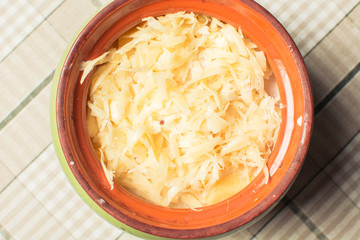 Fresh grated cheese in ceramic pot on crust baking table.
