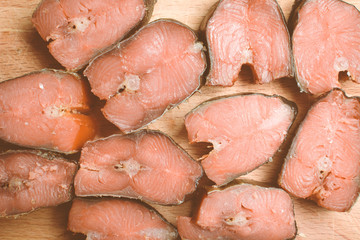 Smoked fish pink salmon sliced on wooden cutting board.
