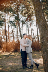 Fototapeta premium Couple in a park. Blonde in a gray jacket. Man with a beard