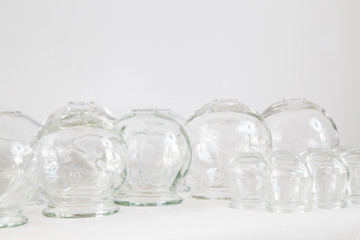 Bańki chińskie, szklane na białym stole na białym tle.