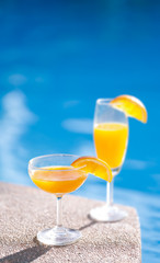 Orange juice mocktail in a poolside background