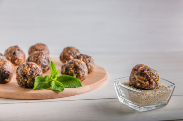 vegetarian food, energy balls of walnuts, dates, prunes, cranberries, honey with sesame
