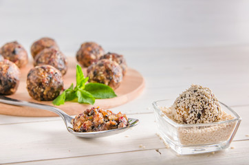 vegetarian food, energy balls of walnuts, dates, prunes, cranberries, honey with sesame
