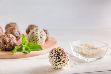 vegetarian food, energy balls of walnuts, dates, prunes, cranberries, honey with sesame
