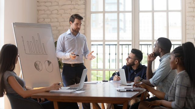 Serious male coach give flip chart presentation to diverse employees