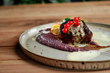 Closeup of piece of barbecue staying on plate with puree