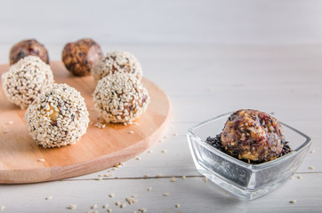vegetarian food, energy balls of walnuts, dates, prunes, cranberries, honey with sesame