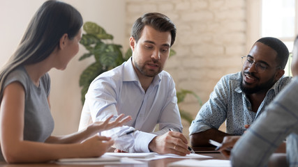 Successful male corporate leader explain paperwork at group office briefing