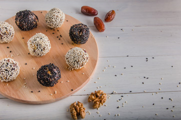 vegetarian food, energy balls of walnuts, dates, prunes, cranberries, honey with sesame