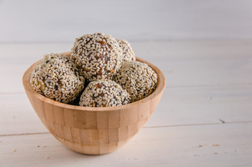 vegetarian food, energy balls of walnuts, dates, prunes, cranberries, honey with sesame