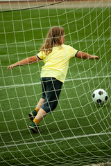 child run soccer (football) player. Boy with ball on green grass