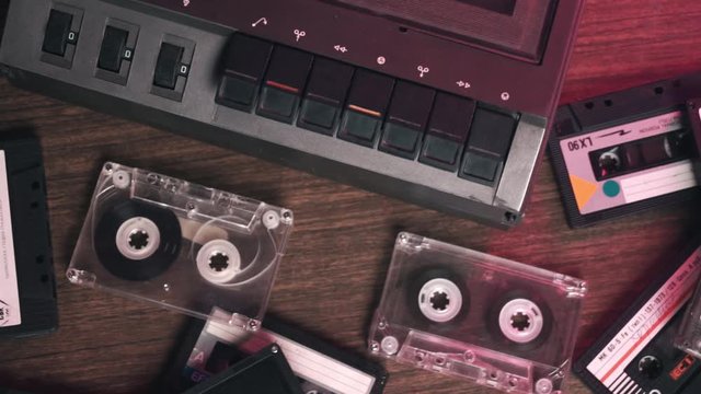 Old retro vintage cassette audio player and many different old retro audio cassettes on the table