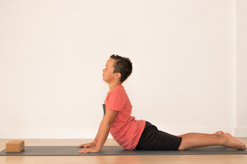 Fototapeta na wymiar Niño joven realizando estiramientos para una clase de yoga