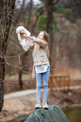 Obraz premium Little girl with a white puppy. A puppy in the hands of a girl