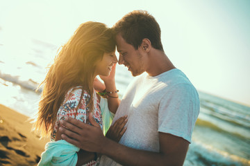 Romantic young couple enjoying summer holidays. Handsome young man with girlfriend on beach.