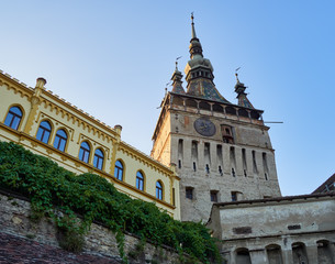 Fototapeta na wymiar Clock tower or tower of the Town Hall and medieval architecture, at the entrance to the citadel of the historic center of the city of Sighisoara, in Romania, a UNESCO World Heritage Site