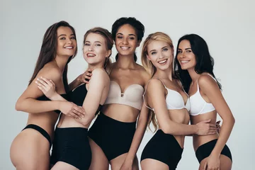 Foto op Plexiglas five sexy multiethnic girls in lingerie embracing and smiling isolated on grey © LIGHTFIELD STUDIOS