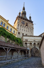 Obraz premium Clock tower or tower of the Town Hall and medieval architecture, at the entrance to the citadel of the historic center of the city of Sighisoara, in Romania, a UNESCO World Heritage Site