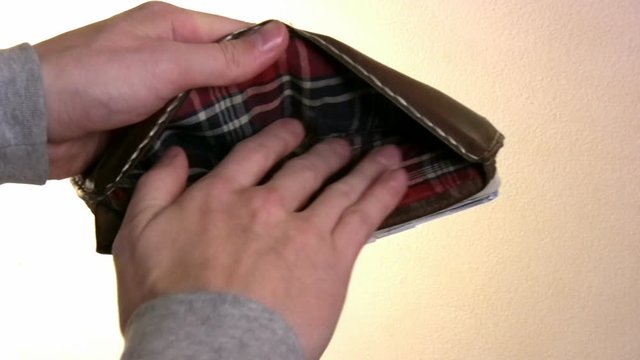 Hand searches wallet for some cash.