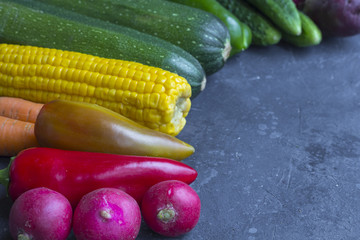 Assortment vegetables on the dark background close up, copy space. Organic foods and fresh vegetables. Autumn harvest consept.