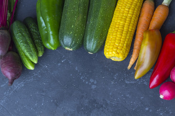 Assortment vegetables on the dark background top view, copy space.