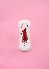 The concept of menstruation and hygiene products for women. Spacer and blood from sparkles and glitter. Transitional age