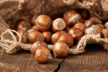 Hazelnut heap on wooden table, selective focus