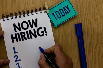 Word writing text Now Hiring. Business concept for announcing that certain company seeking for new talents Man holding marker notebook clothespin reminder wooden table cup coffee