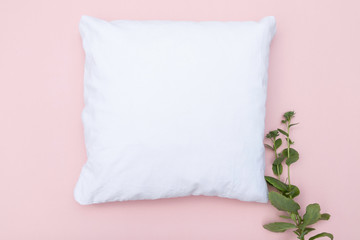 Blank white cushion mock up on a pink background and green plant - empty for own design