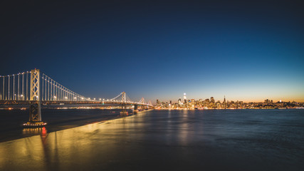 Fototapeta na wymiar Panoramic beautiful scenic view of the Oakland Bay Bridge and the San Francisco city in the evening, California