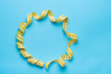 Measuring tape on a blue background. Close up