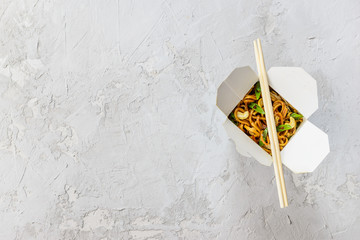 Noodles box on a gray background. Asian cuisine, horizontal orientation, flat lay.