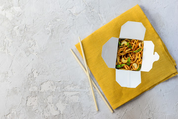 Noodles box on a gray background. Asian cuisine, horizontal orientation, flat lay.