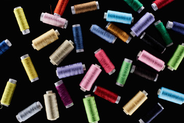 top view of bright and colorful threads isolated on black