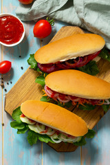 Traditional american fast food. Barbecue grilled Hot dog with fresh vegetables on wooden table. Top view.