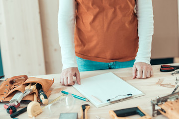 Female carpenter with hands on the desk