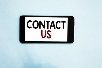 Text sign showing Contact Us. Conceptual photo Group of person that rendering costumer service through telecom Cell phone white screen over light blue background text messages apps