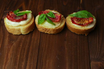 Tasty  with sun-dried tomatoes on wooden table