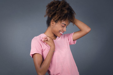 Shot of happy young woman with positive smile, has long hair, rejoices having weekend and good rest after hard working exhausting week, isolated on gray wall.