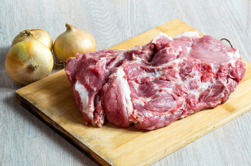 Raw meat and onion on wooden board