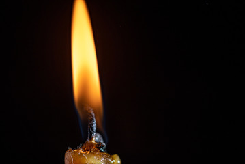 The remainder of the burning candle on a black background.