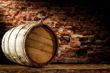 A barrel on wooden table and brick wall background.