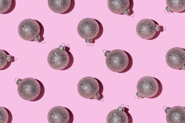 Pattern made of silver balls on pink background.