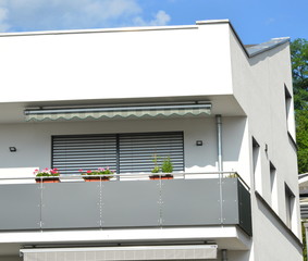 Moderne Betonbalkone und Attika-Schutzbleche an Neubau-Hausfront